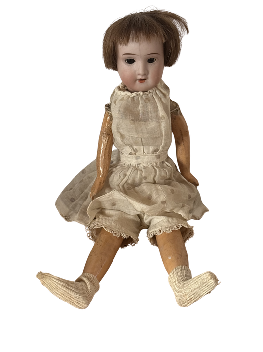 Bambola d’epoca con testa in ceramica e braccia e gambe in pasta di legno