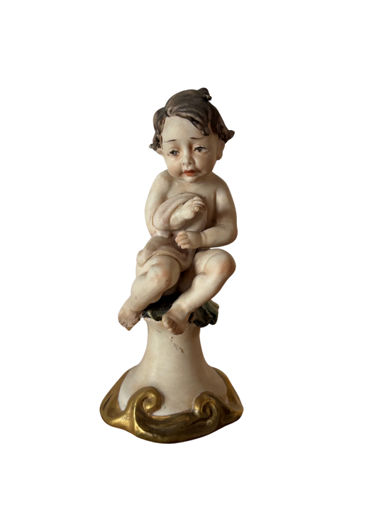 Statuetta di putto con coperta