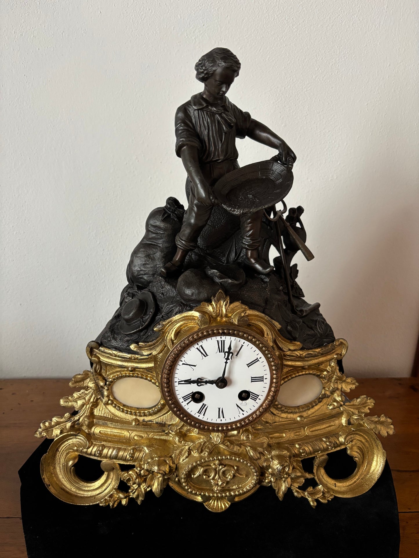 Orologio da camino antico con giovane cercatore d’oro