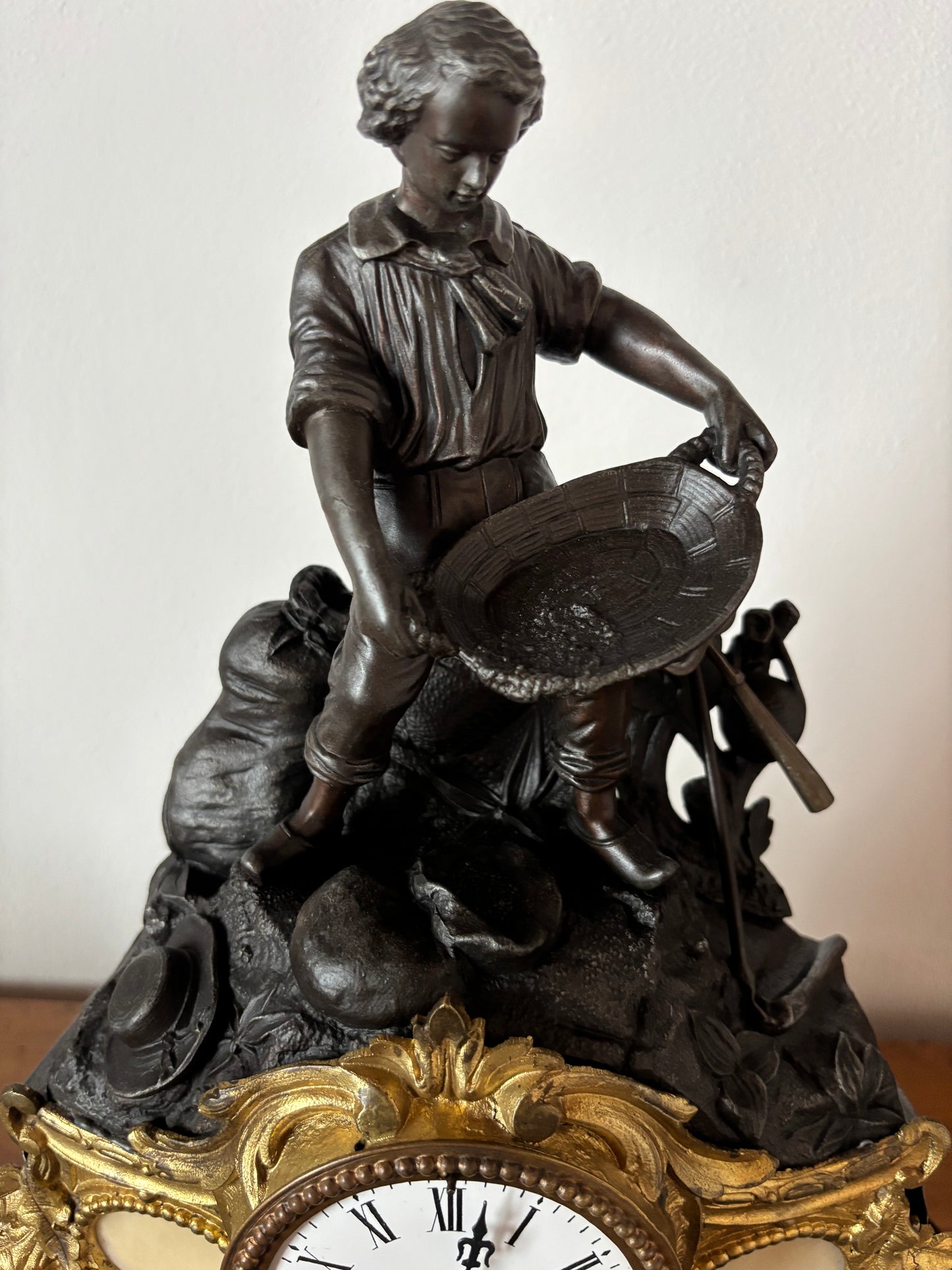 Orologio da camino antico con giovane cercatore d’oro