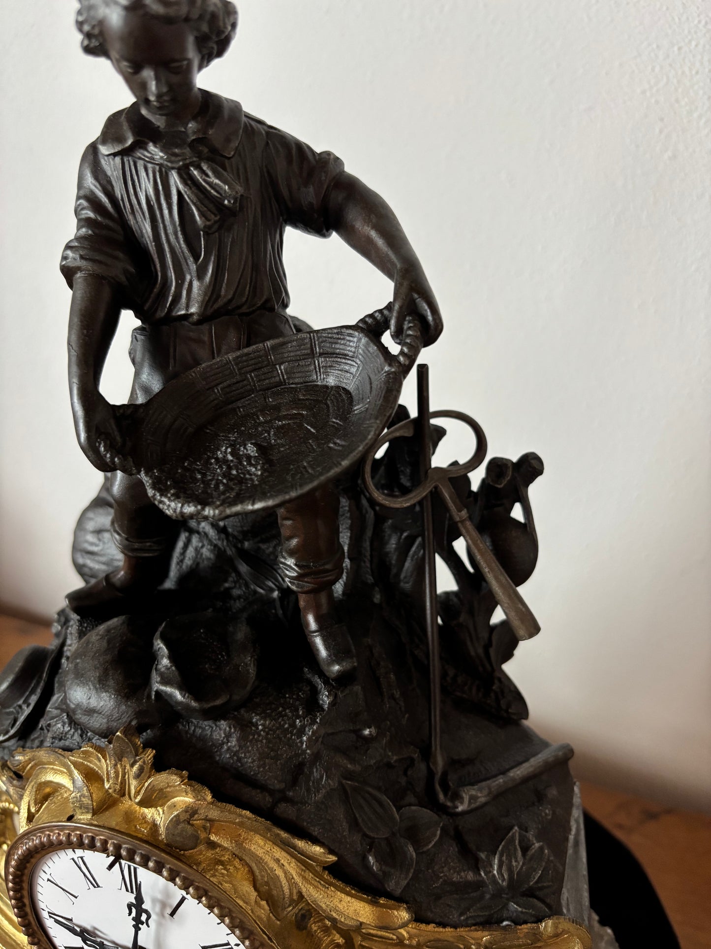 Orologio da camino antico con giovane cercatore d’oro