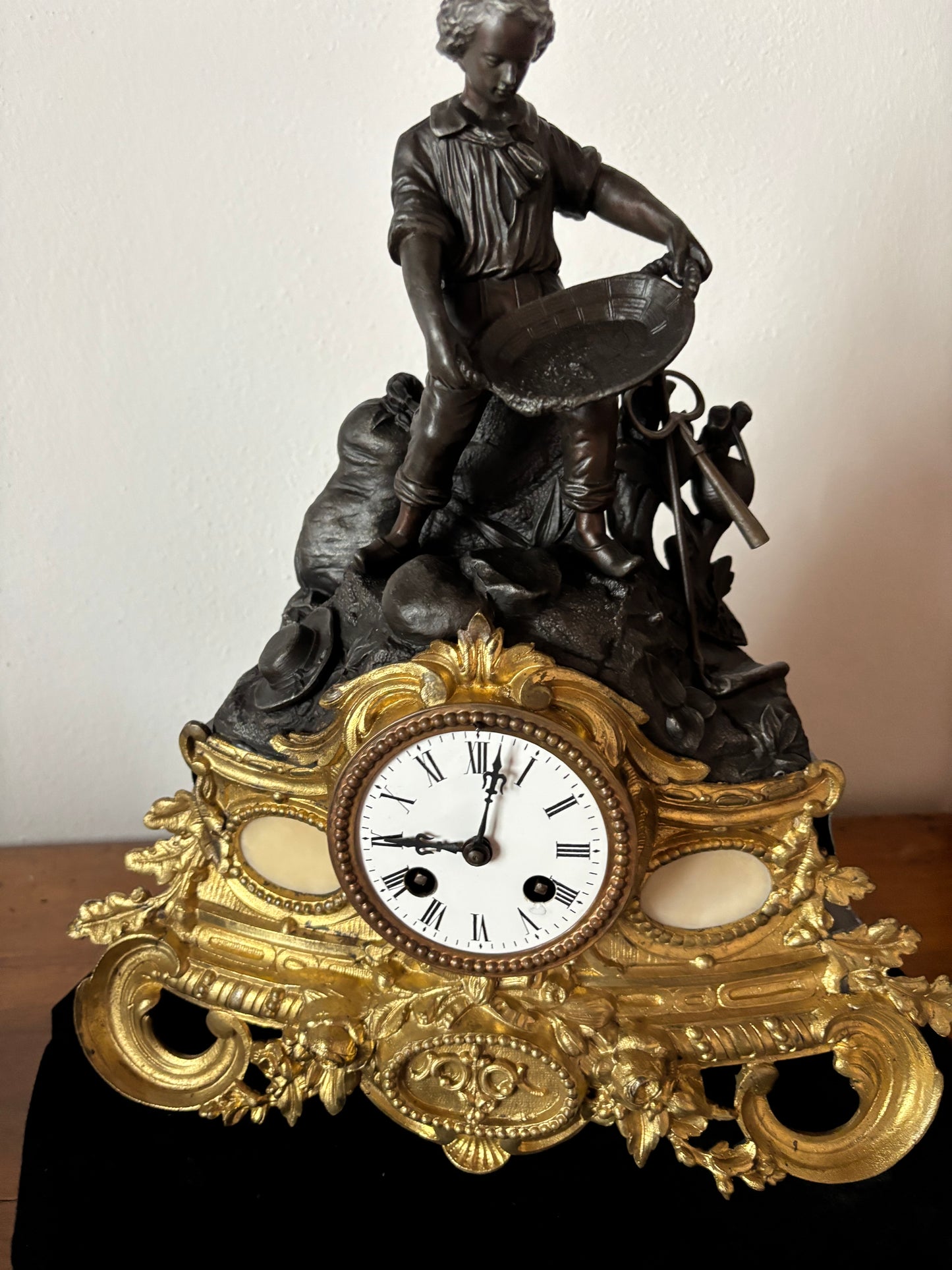 Orologio da camino antico con giovane cercatore d’oro