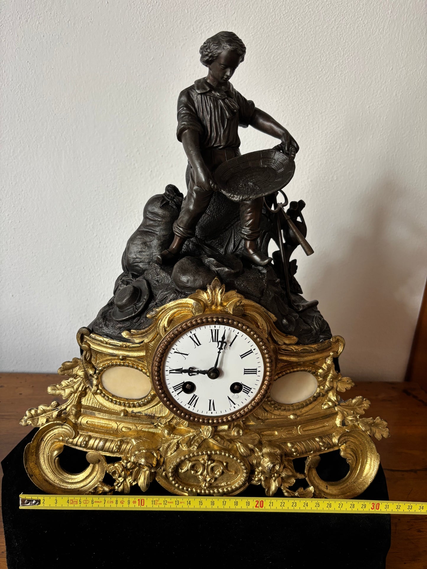 Orologio da camino antico con giovane cercatore d’oro