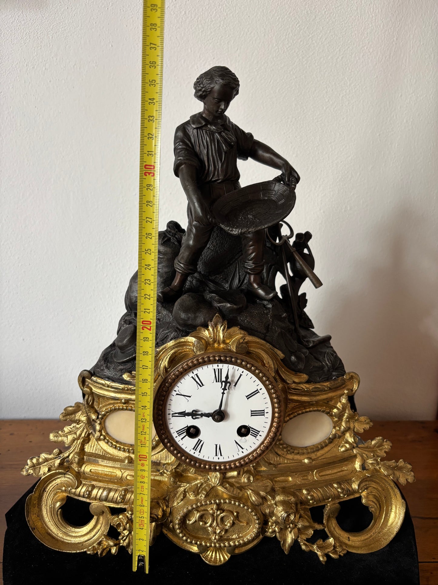 Orologio da camino antico con giovane cercatore d’oro