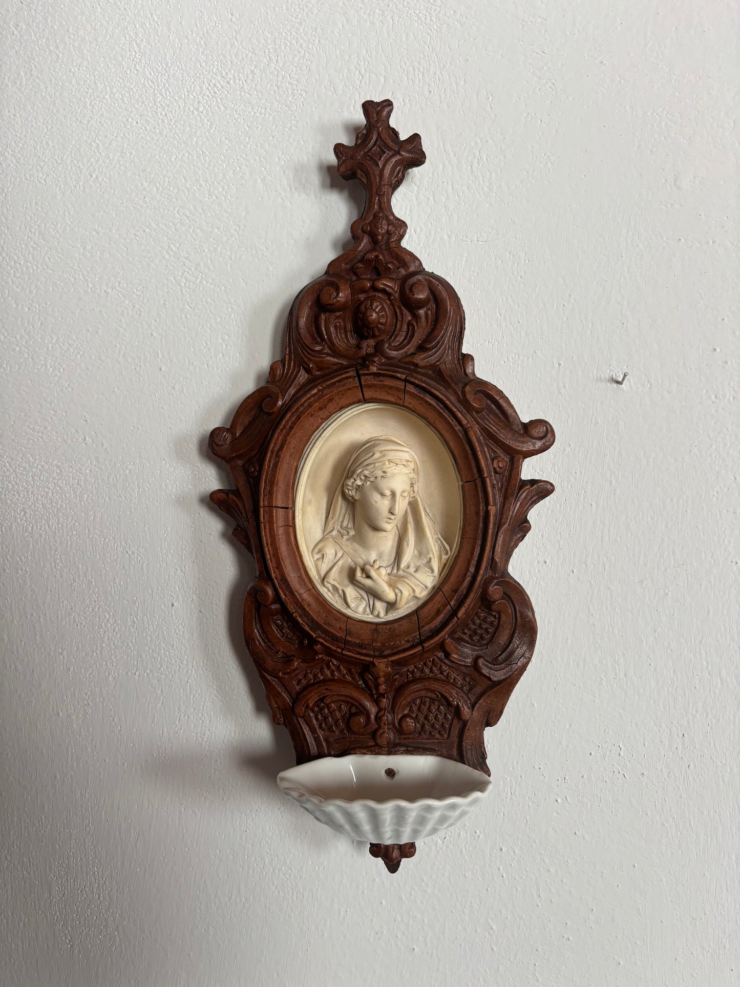 Acquasantiera in legno con decorazioni in stucco e Madonna in materiale petroso