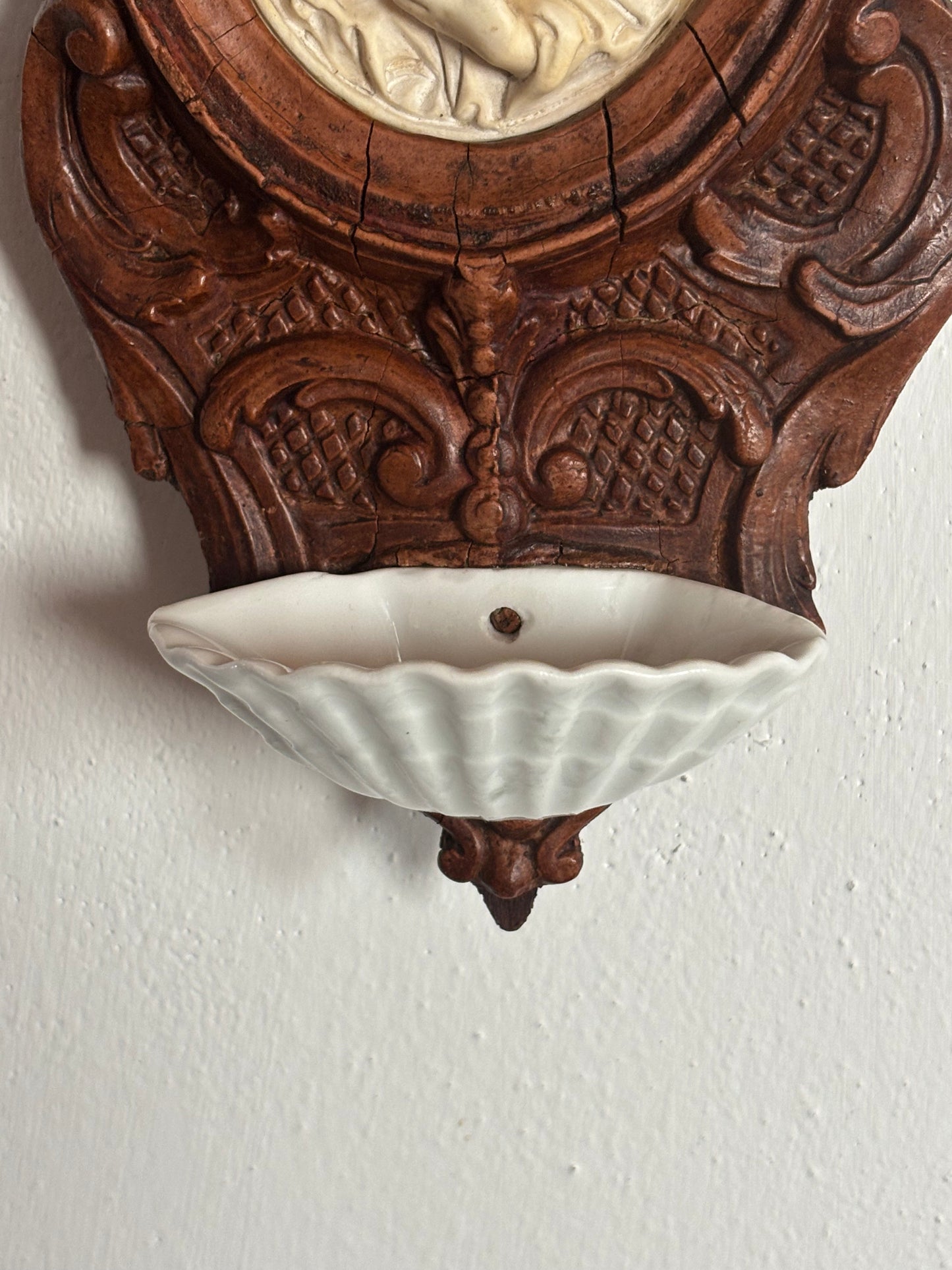 Acquasantiera in legno con decorazioni in stucco e Madonna in materiale petroso