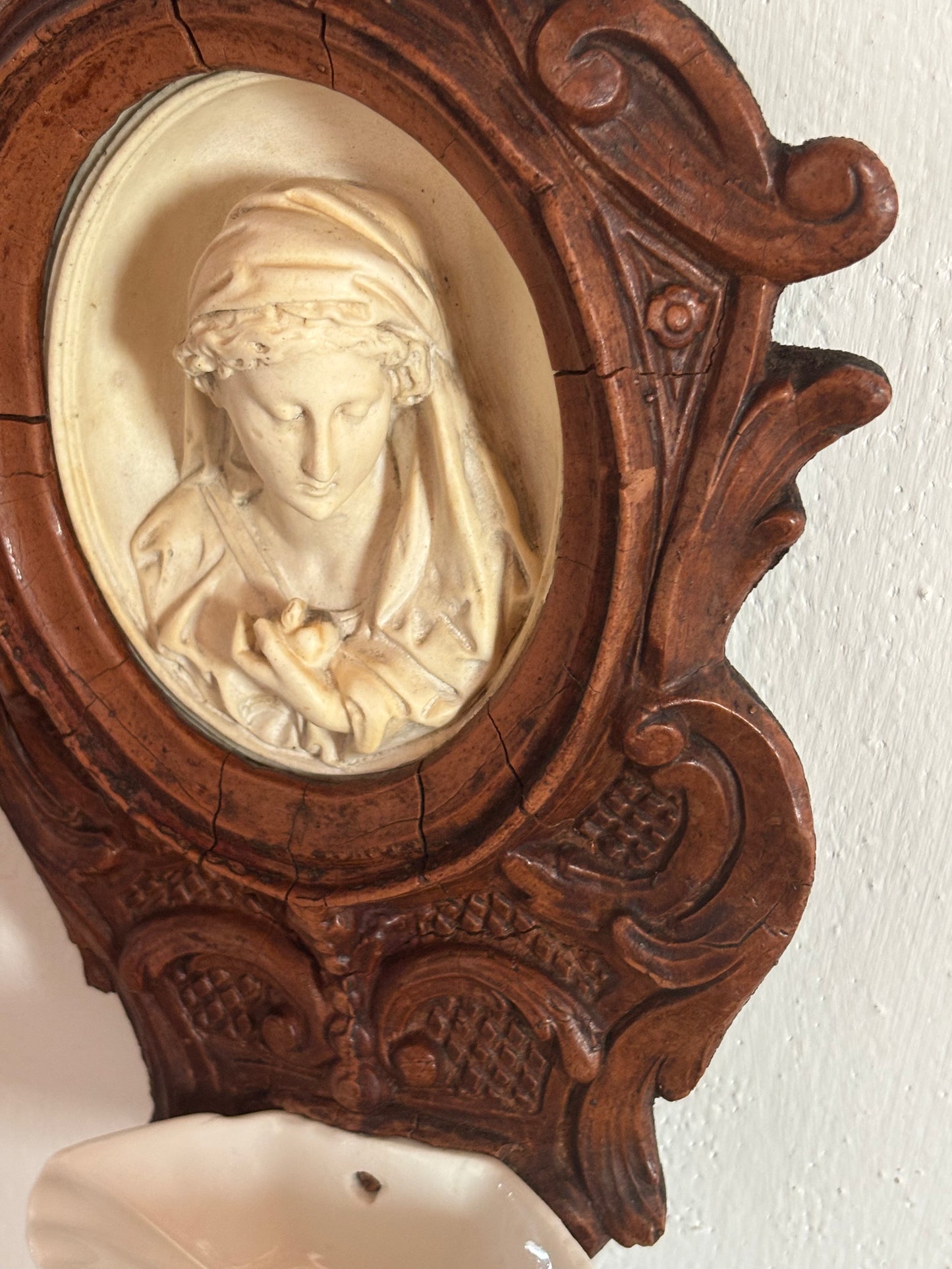 Acquasantiera in legno con decorazioni in stucco e Madonna in materiale petroso