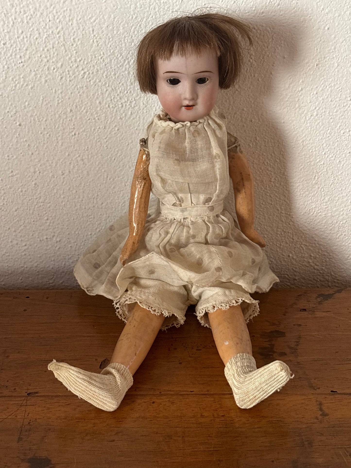 Bambola d’epoca con testa in ceramica e braccia e gambe in pasta di legno
