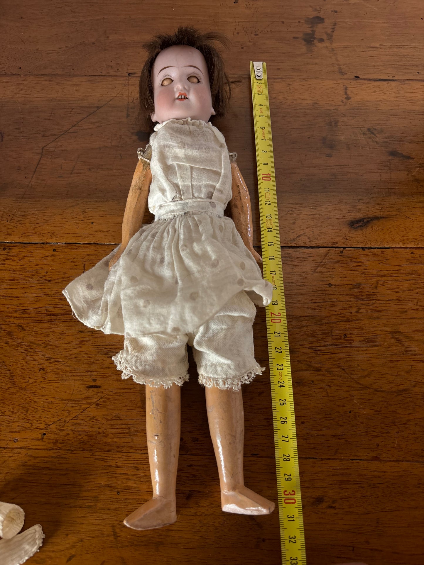 Bambola d’epoca con testa in ceramica e braccia e gambe in pasta di legno