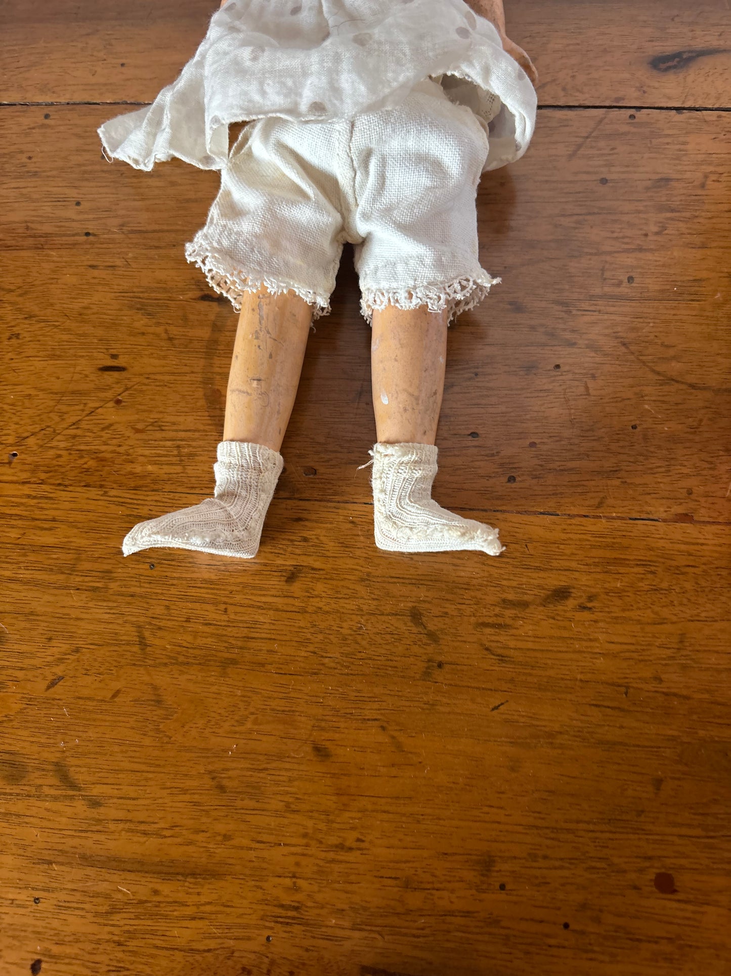 Bambola d’epoca con testa in ceramica e braccia e gambe in pasta di legno