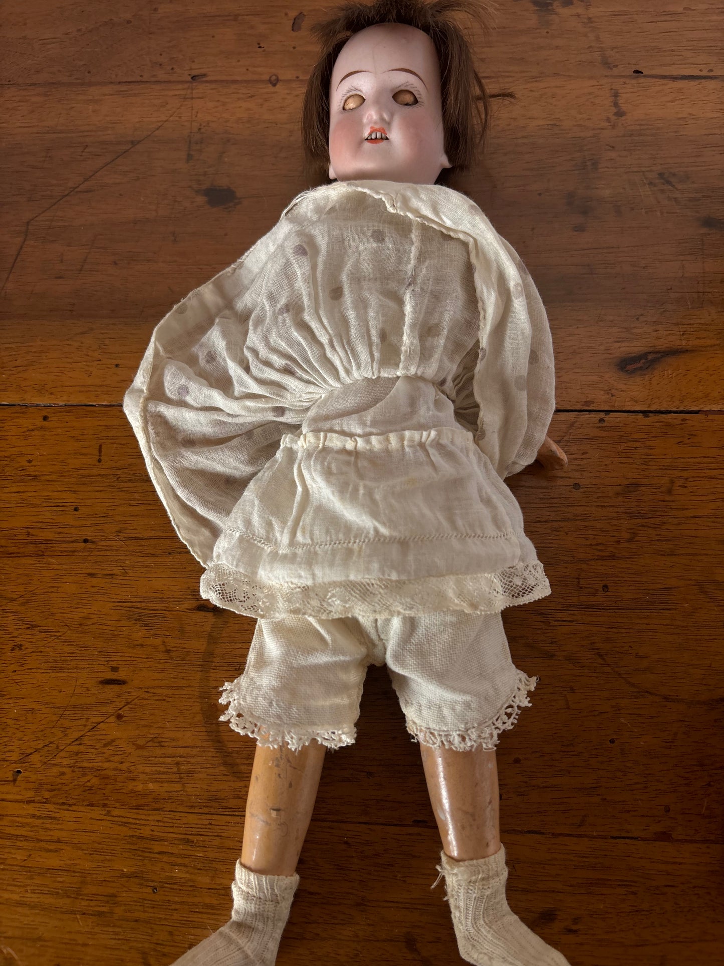 Bambola d’epoca con testa in ceramica e braccia e gambe in pasta di legno
