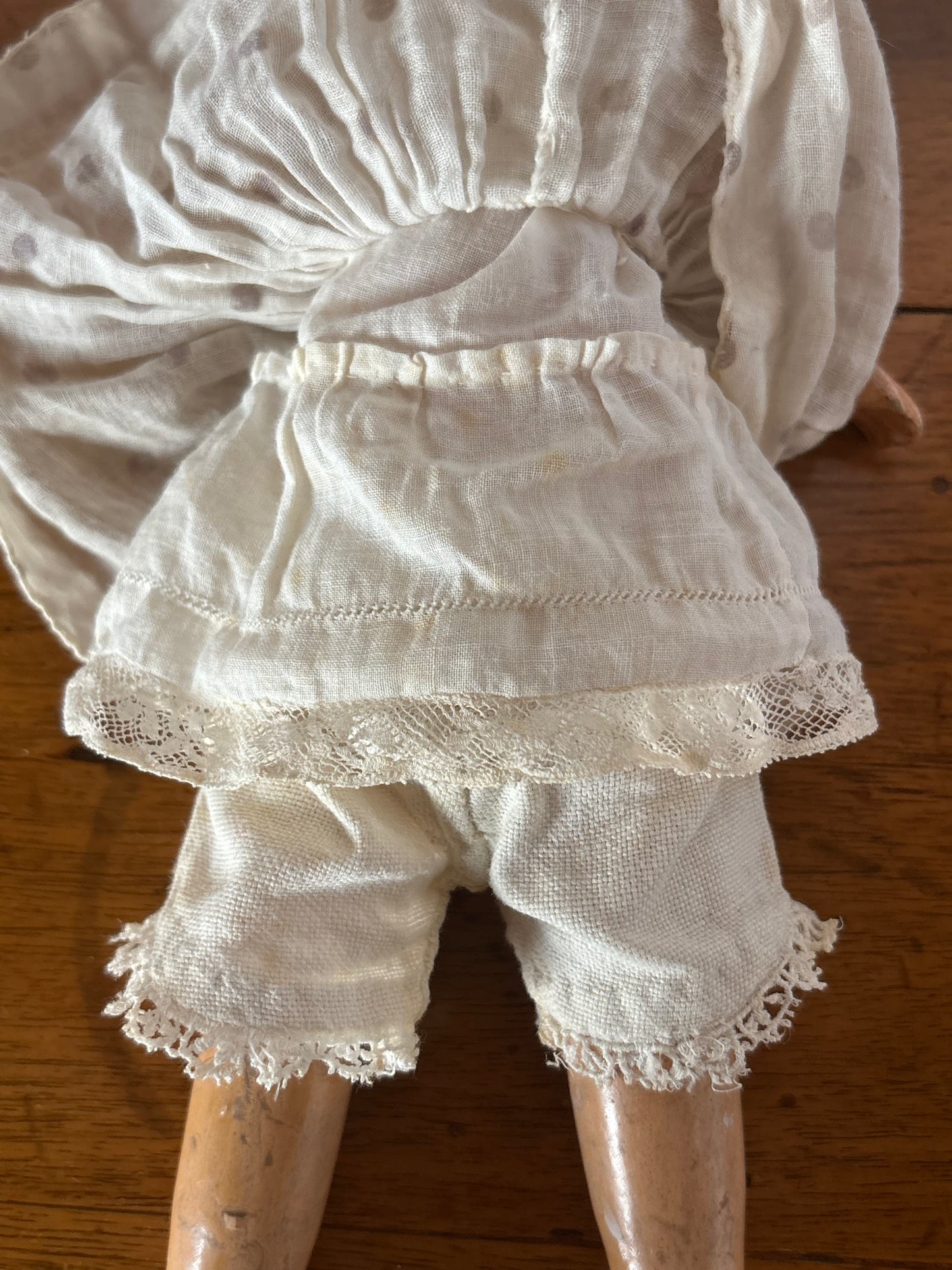 Bambola d’epoca con testa in ceramica e braccia e gambe in pasta di legno