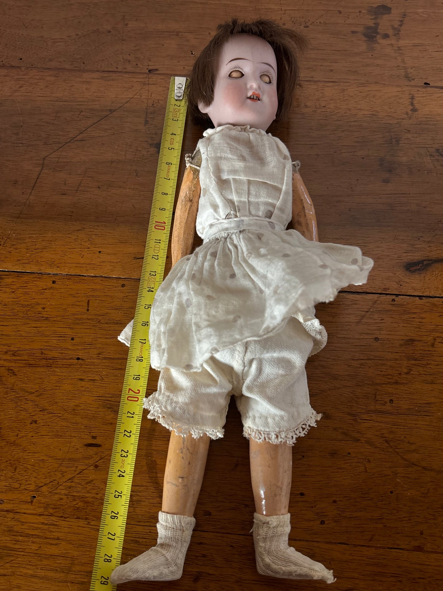 Bambola d’epoca con testa in ceramica e braccia e gambe in pasta di legno