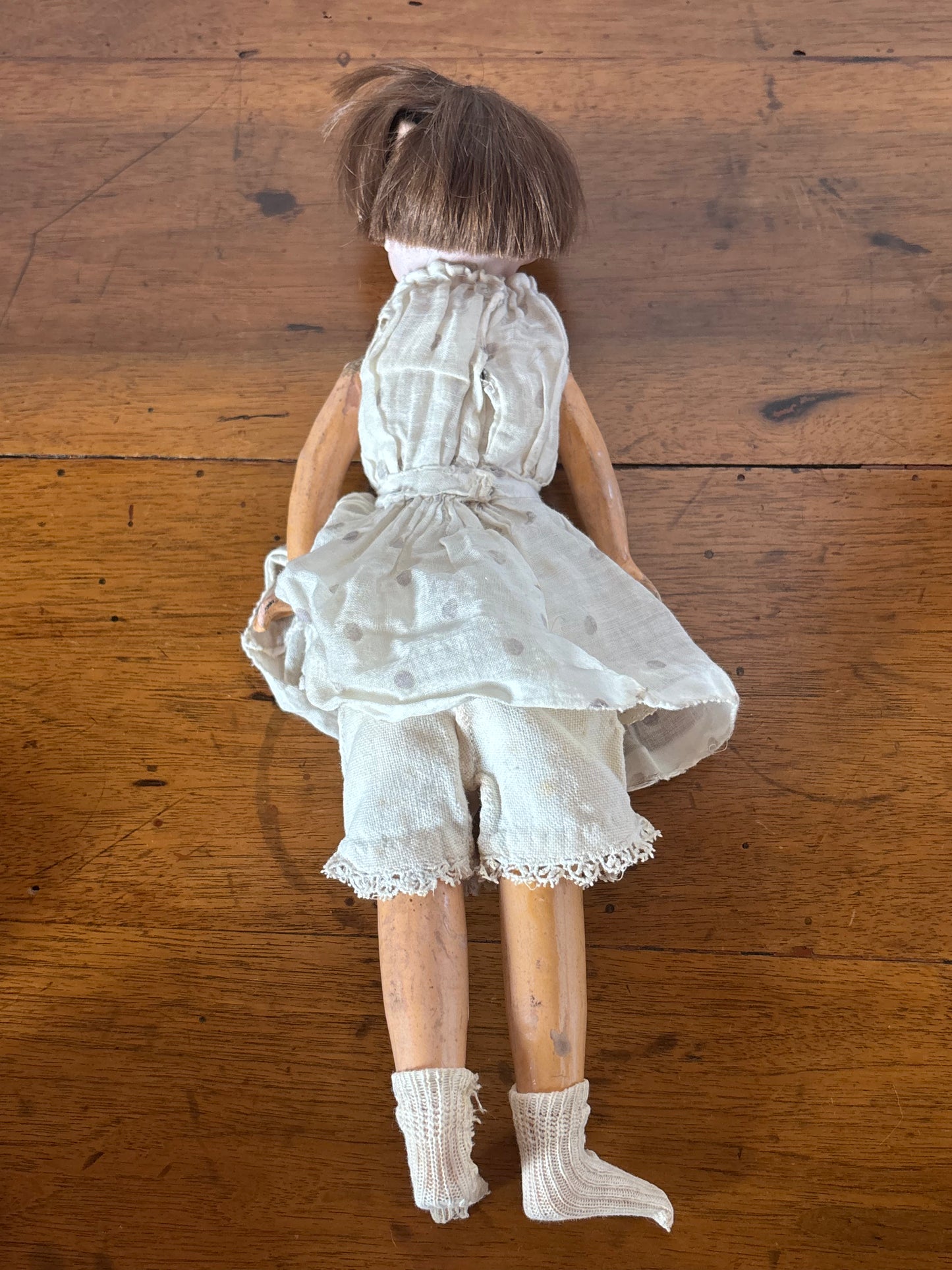 Bambola d’epoca con testa in ceramica e braccia e gambe in pasta di legno