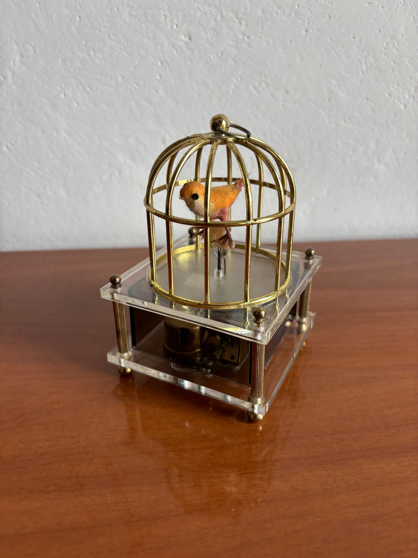 Vogel in Käfig mit Vintage‑Spieluhr