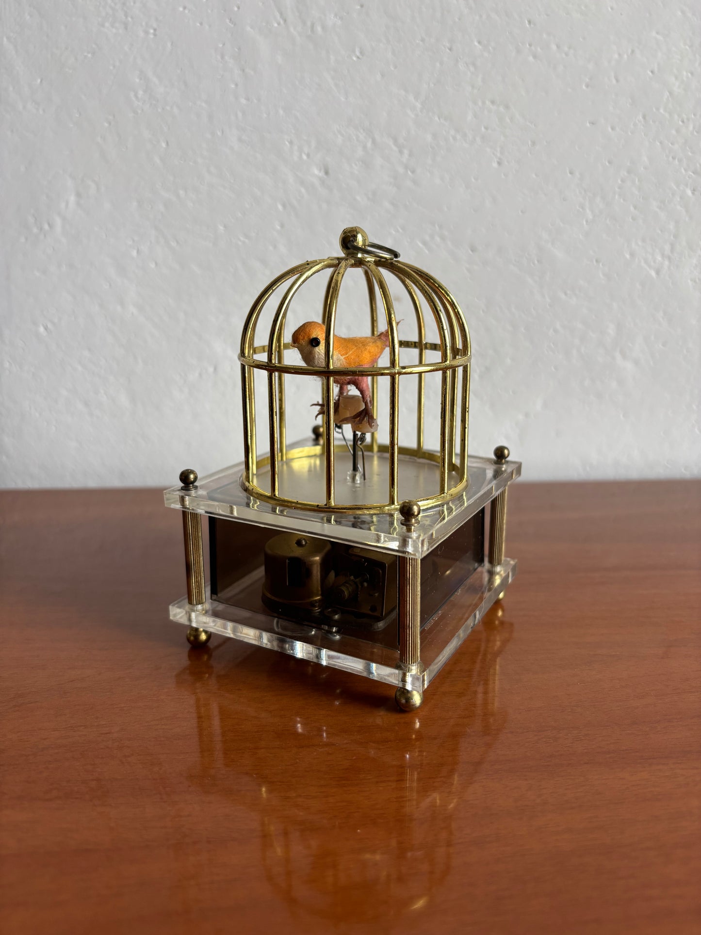 Vogel in Käfig mit Vintage‑Spieluhr