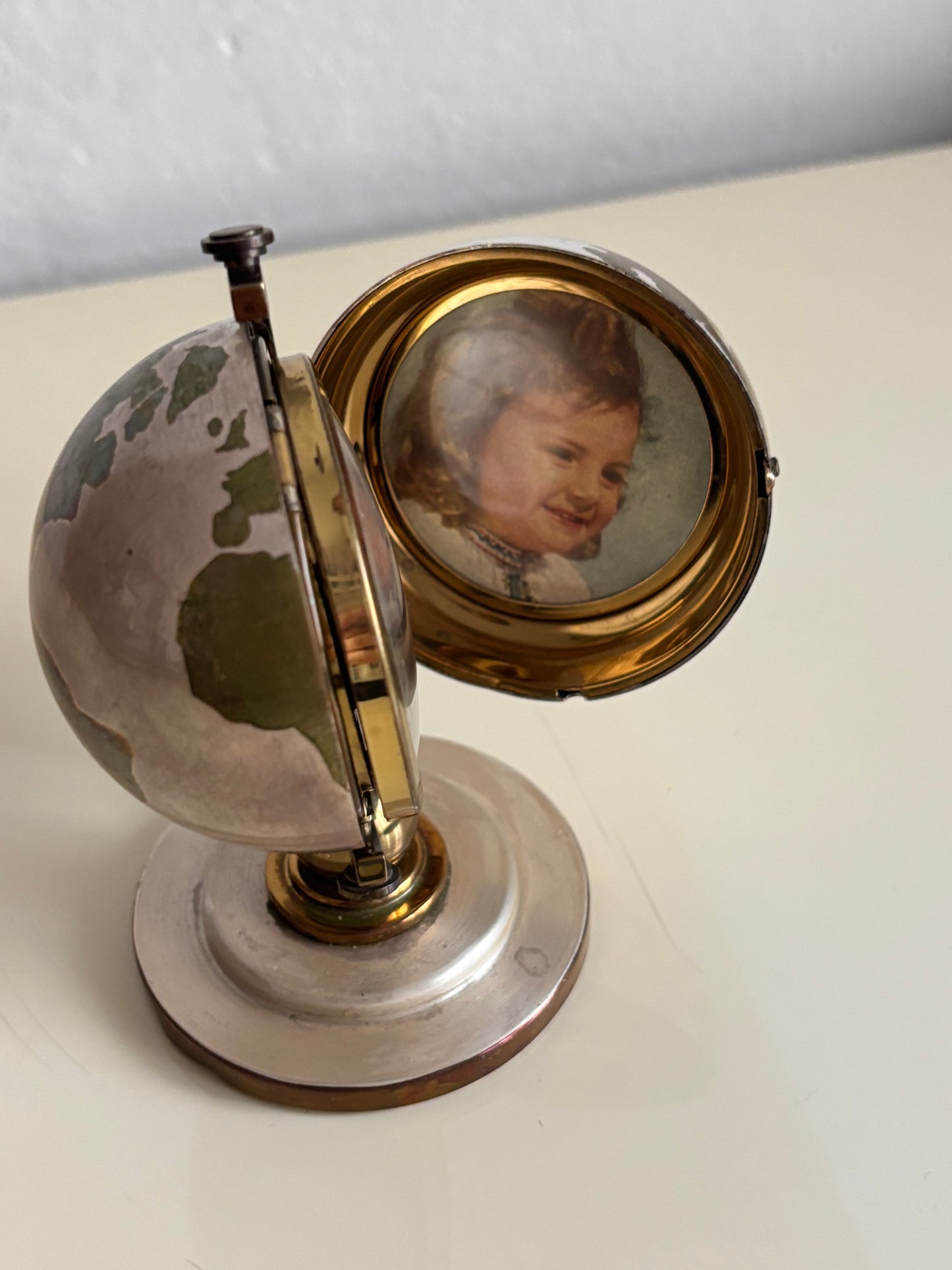 Piccolo mappamondo in metallo con orologio a carica Meridiana e porta foto vintage