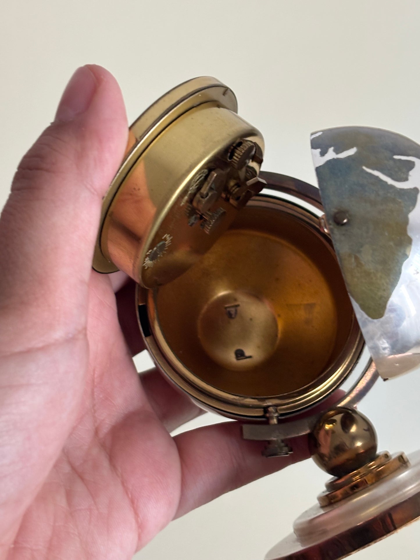 Piccolo mappamondo in metallo con orologio a carica Meridiana e porta foto vintage