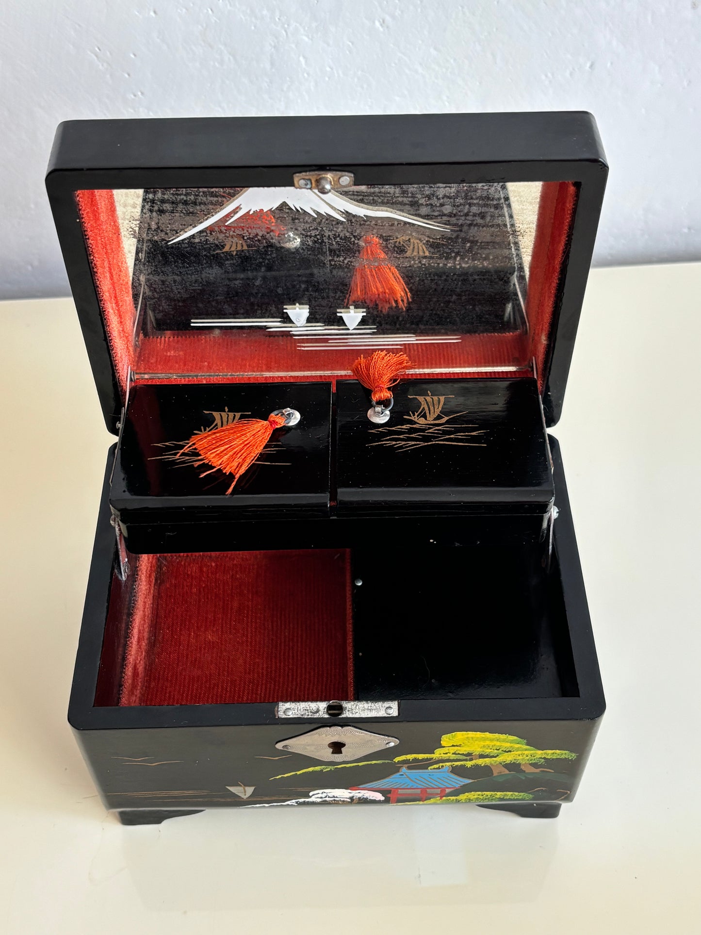 Small vintage music box with key, lacquered case and Mount Fuji on the mirror