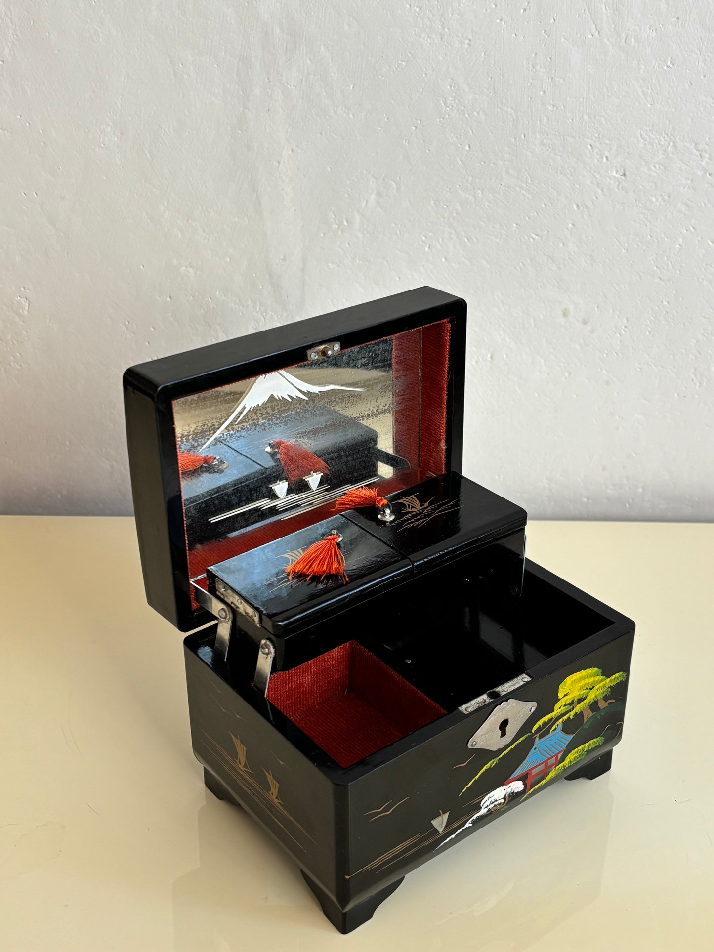 Small vintage music box with key, lacquered case and Mount Fuji on the mirror