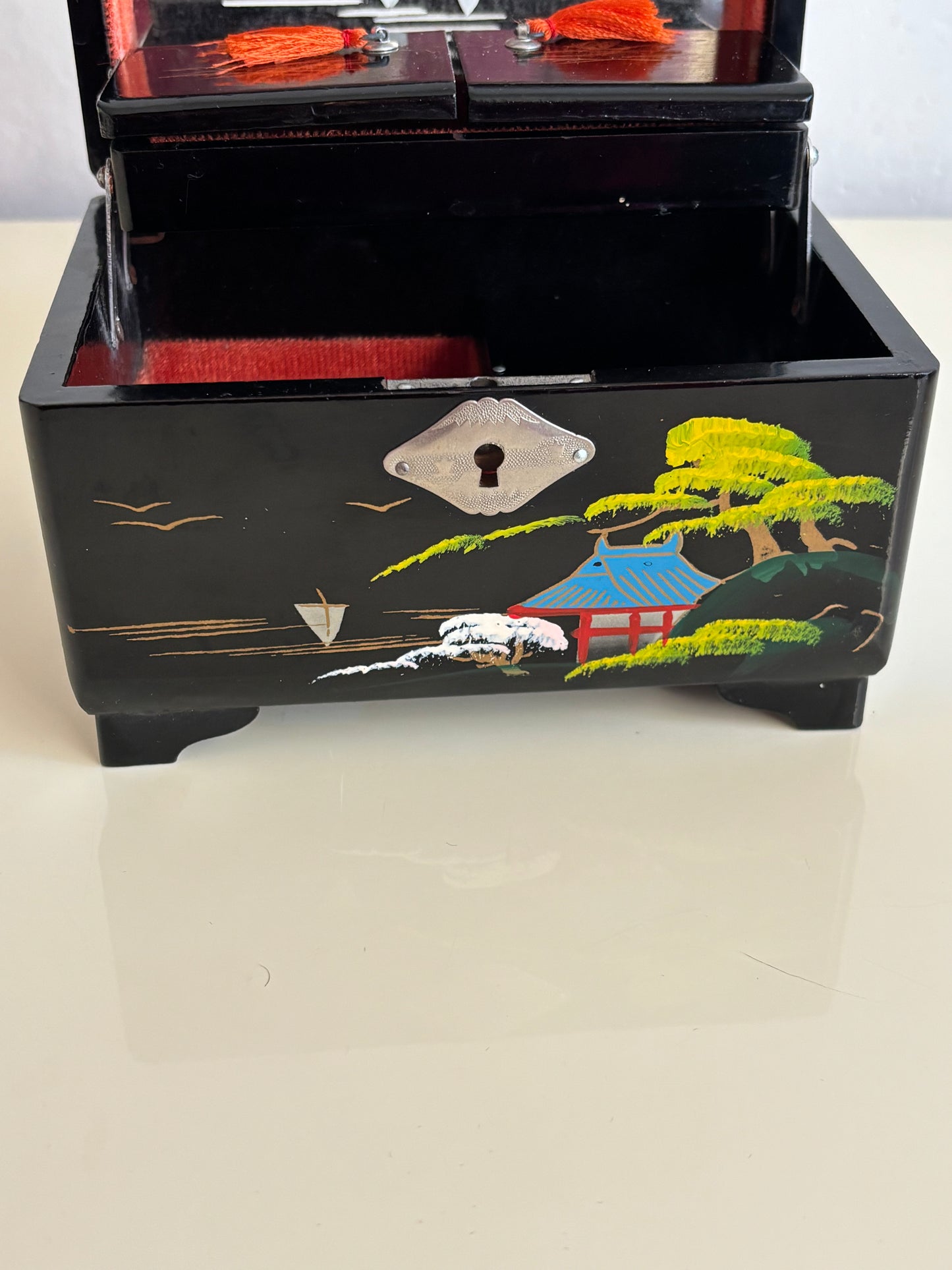 Small vintage music box with key, lacquered case and Mount Fuji on the mirror