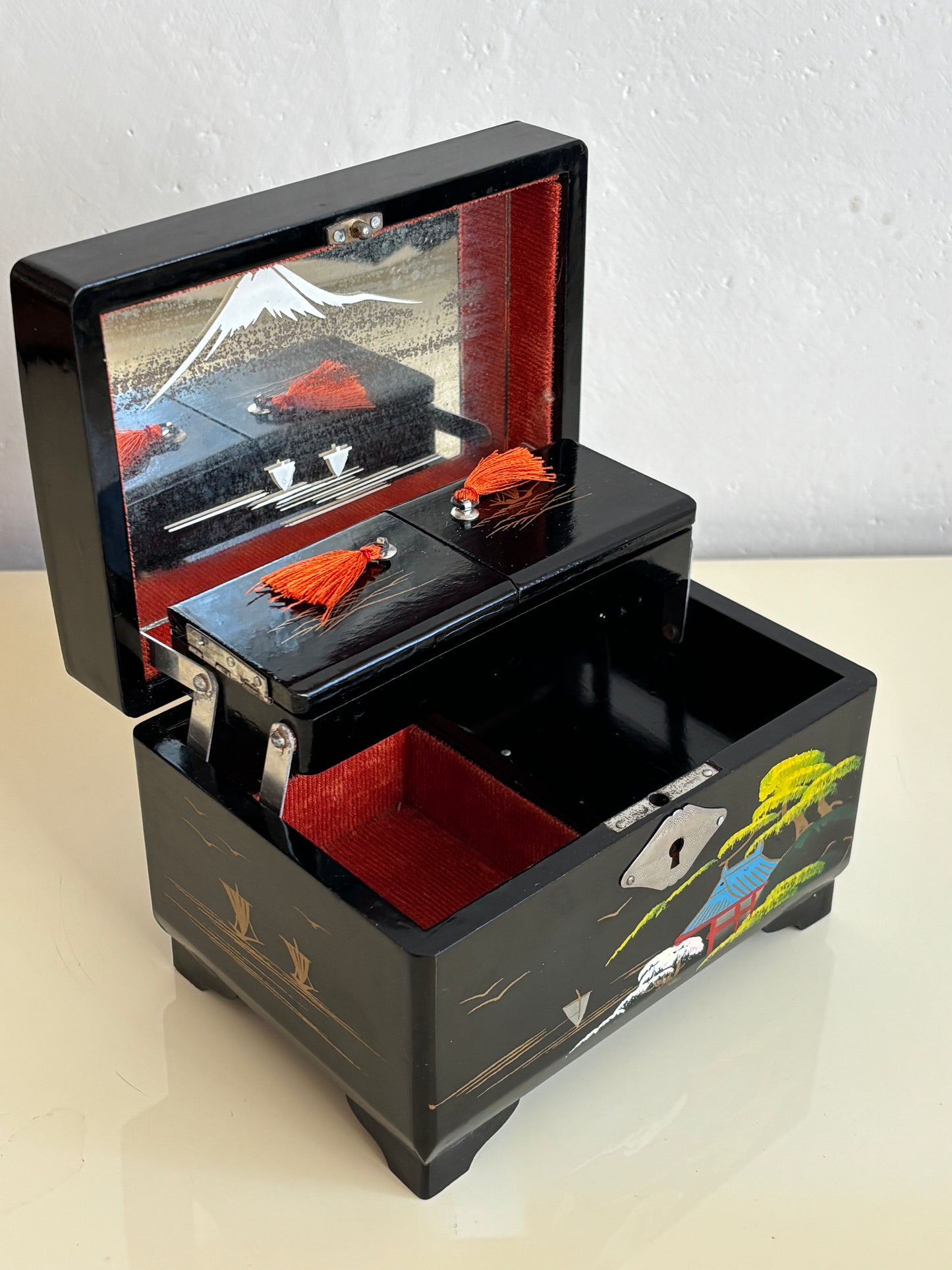 Small vintage music box with key, lacquered case and Mount Fuji on the mirror