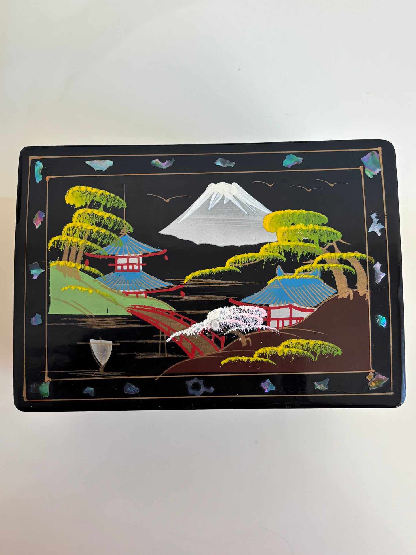 Small vintage music box with key, lacquered case and Mount Fuji on the mirror