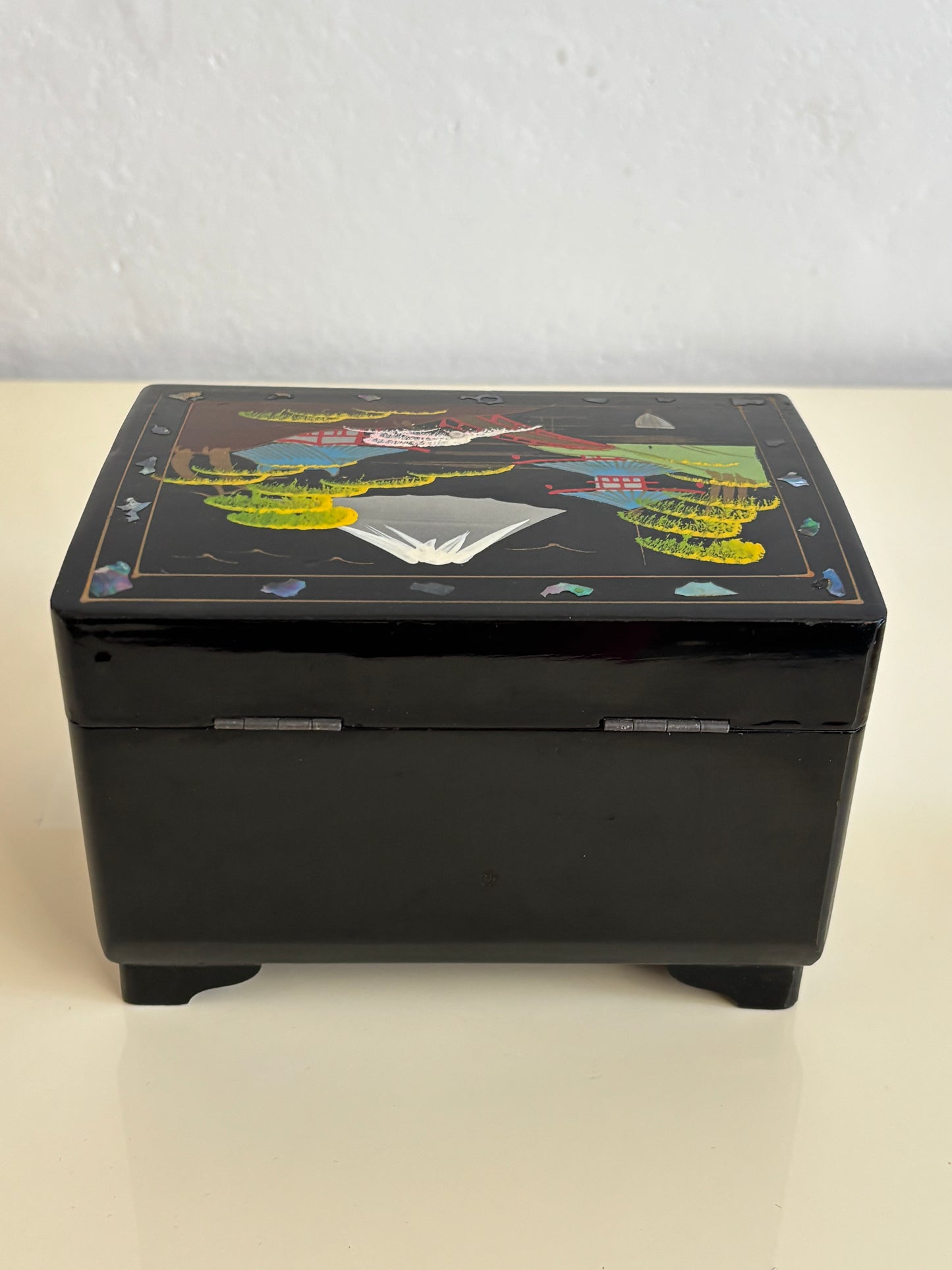 Small vintage music box with key, lacquered case and Mount Fuji on the mirror