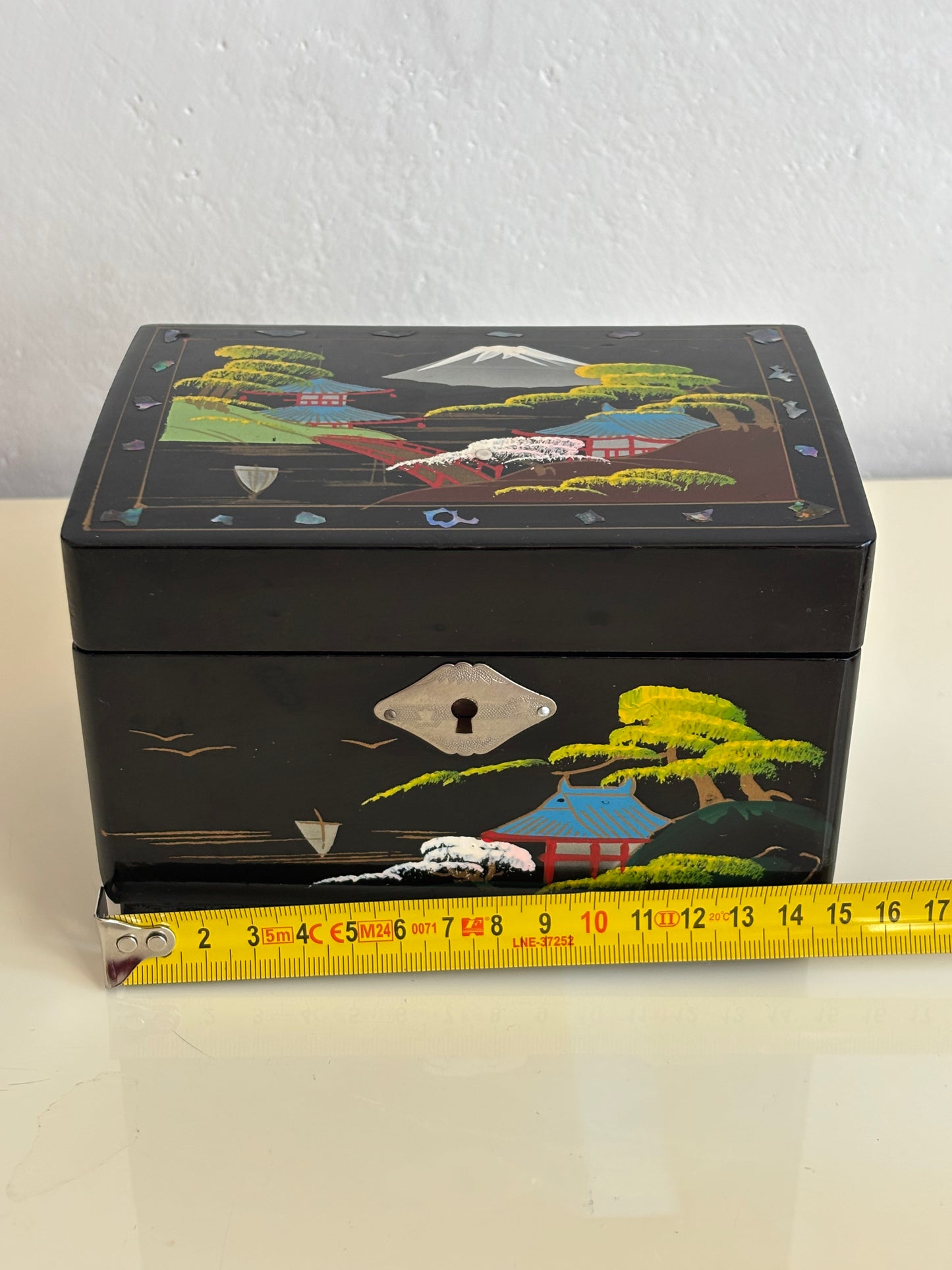 Small vintage music box with key, lacquered case and Mount Fuji on the mirror