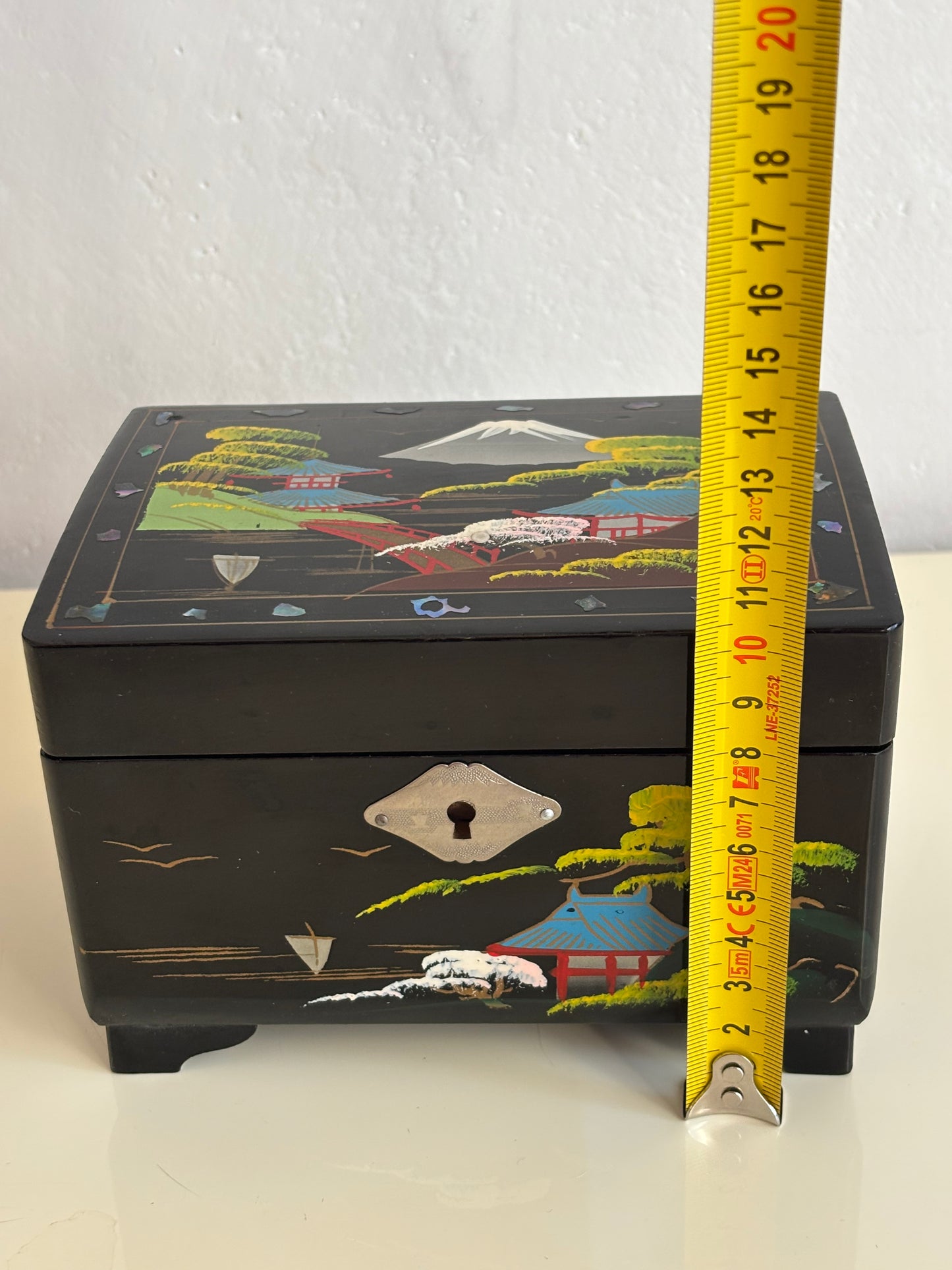 Small vintage music box with key, lacquered case and Mount Fuji on the mirror