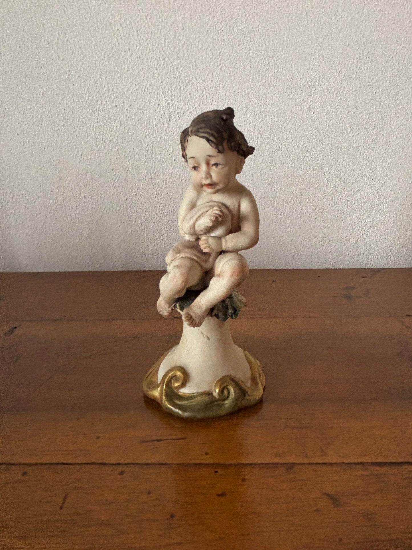 Statuetta di putto con coperta