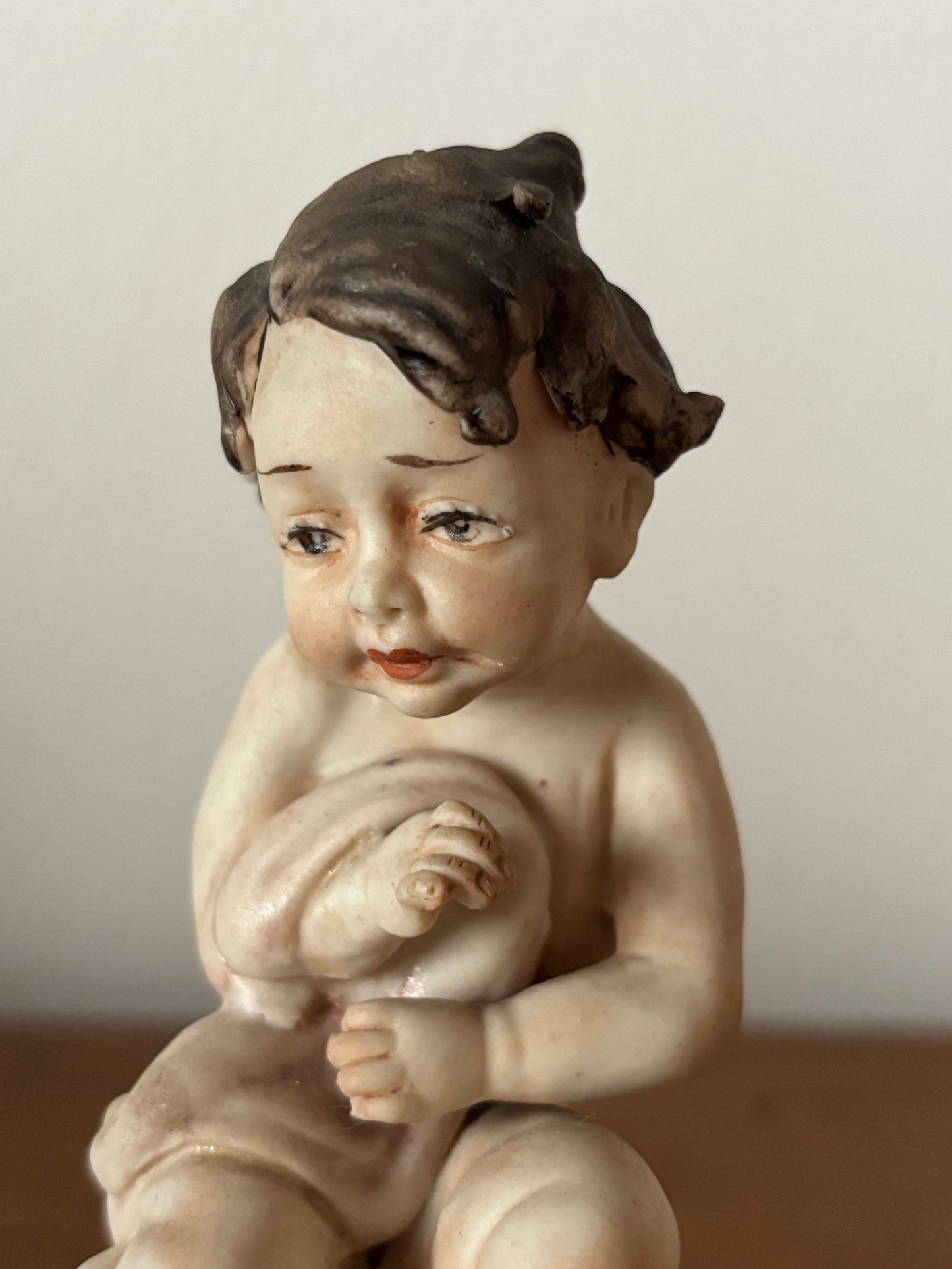 Statuetta di putto con coperta